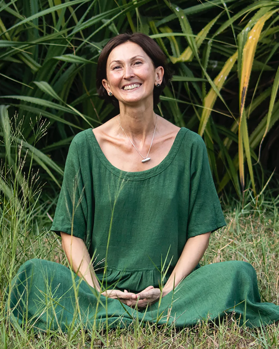 Sarita Arya seated in green in a tropical garden