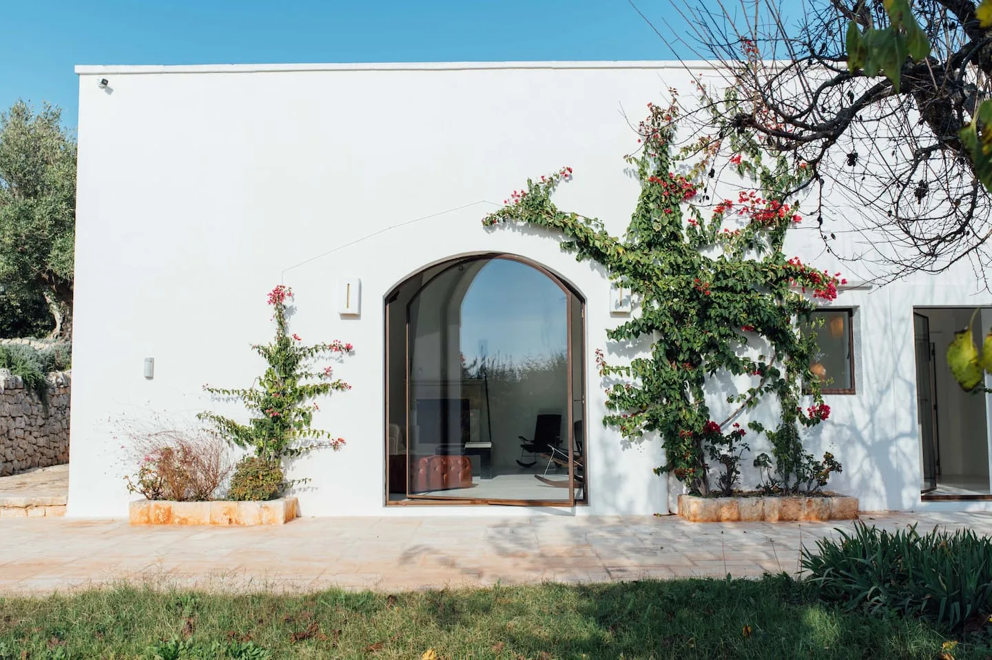 White masseria facade opening onto a garden
